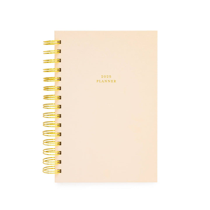 Gold spiral-bound planner with white pages and a pale pink hardcover.