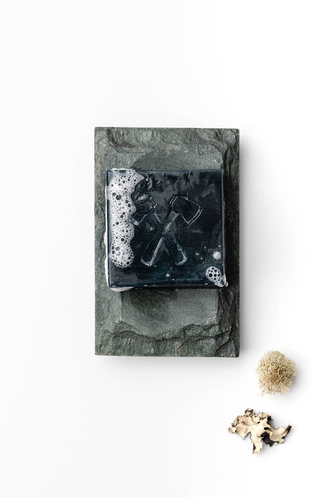 Close-up of the charcoal soap’s rich lather, showcasing its detoxifying properties.