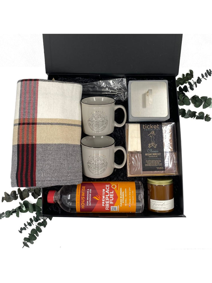 Campfire Cozy gift box with a tabletop fire pit, bio ethanol fuel, artisan s’mores kit, campfire mugs, plaid blanket, and soy candle for a cozy glamping experience.