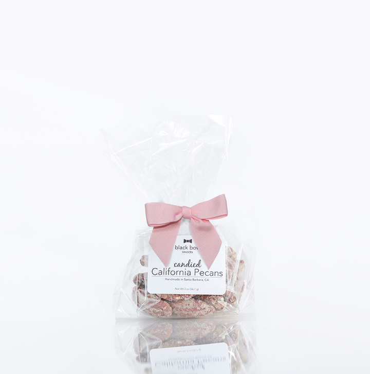 Gourmet candied pecans tied with a pink ribbon, perfect for gifting.