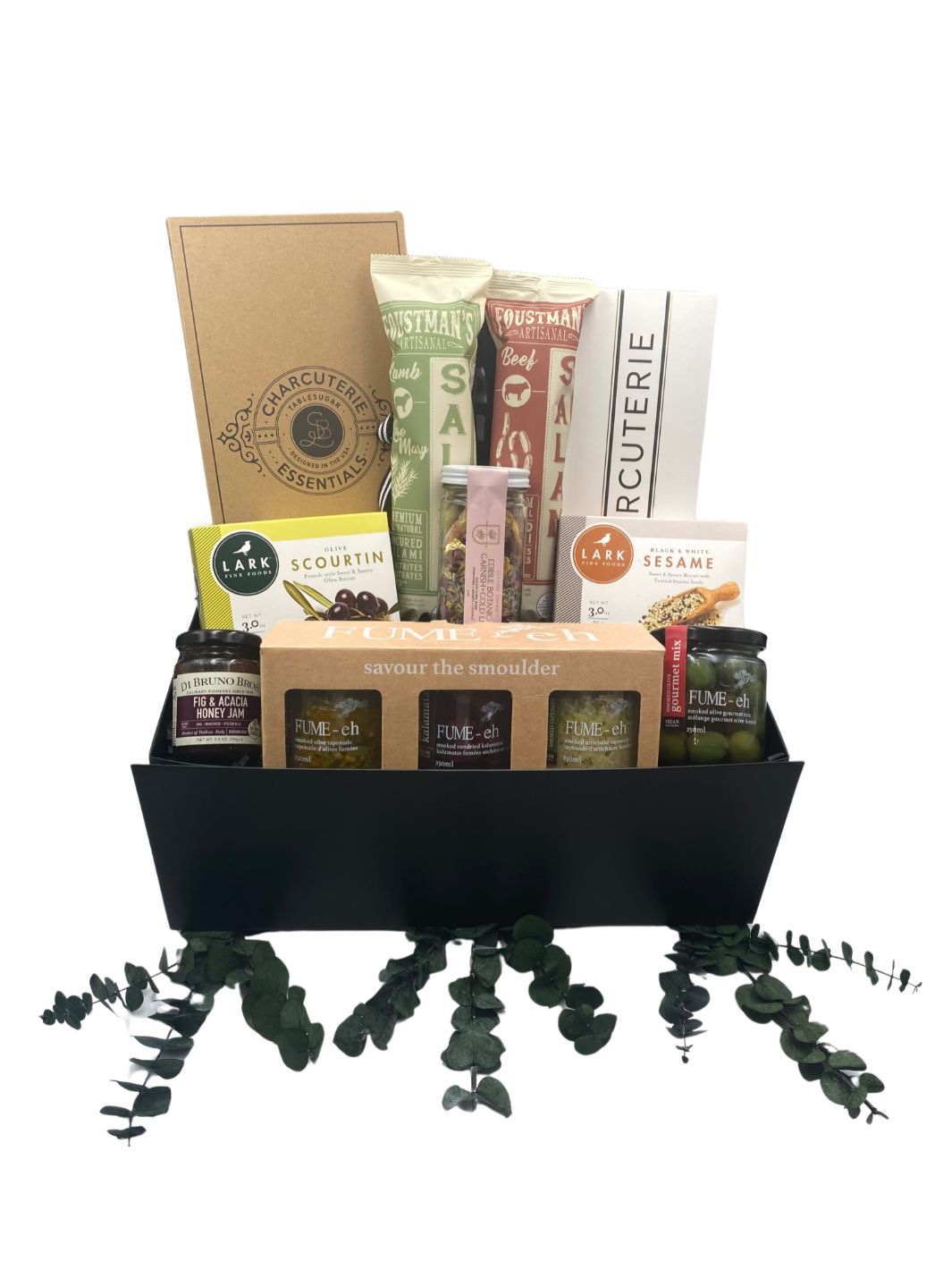 Charcuterie Essentials Gift Box with knives, list pad, tapenade trio, smoked olives, fig and honey jam, savory biscuits, salami, and edible botanical garnish.