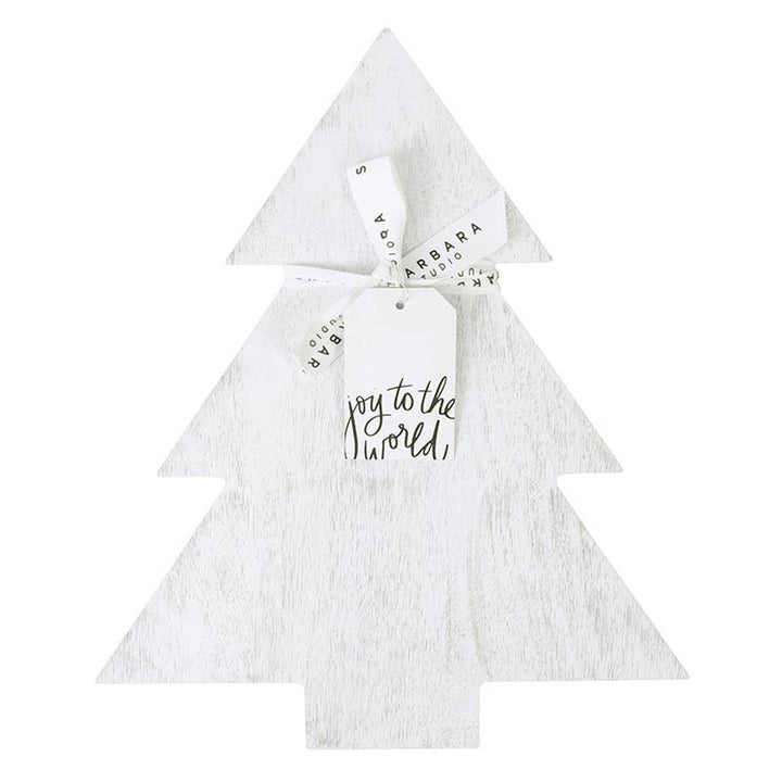 Christmas tree-shaped board in whitewashed mango wood tied with a ribbon and gift tag that states "Joy to the World".