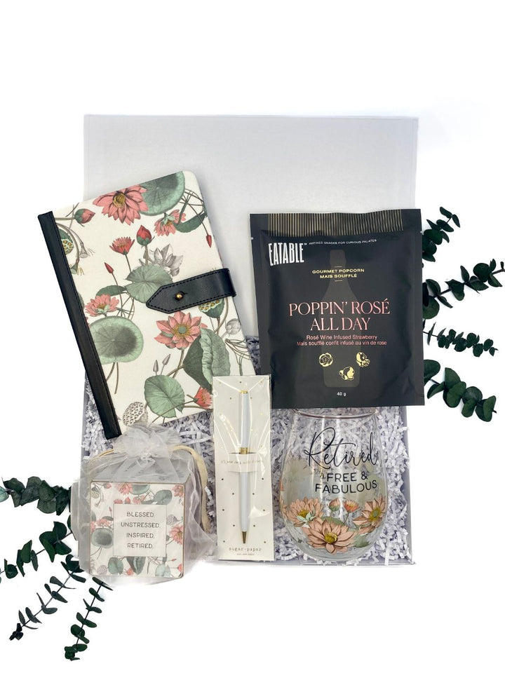 Free & Fabulous Retirement Gift Set with floral journal, twist pen, stemless wine glass, quote cube, and gourmet popcorn, presented in a magnetic closure gift box.