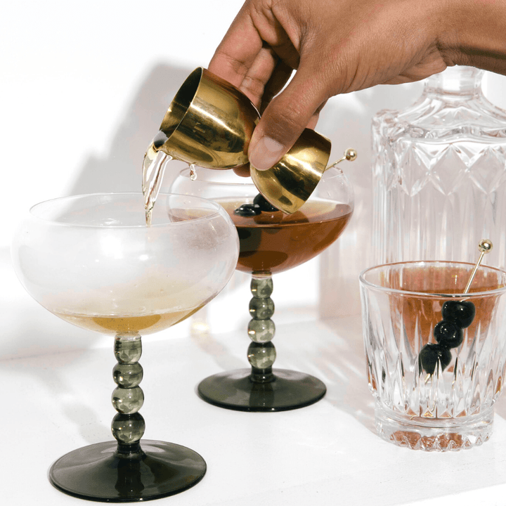 Gold Bell Shaped Cocktail Jigger being used to make a cocktail.