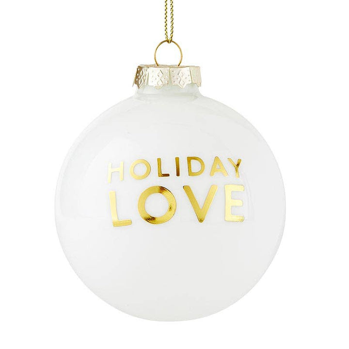 Close-up of the “Holiday Love” glass ornament featuring elegant gold script and a lurex cord for hanging.