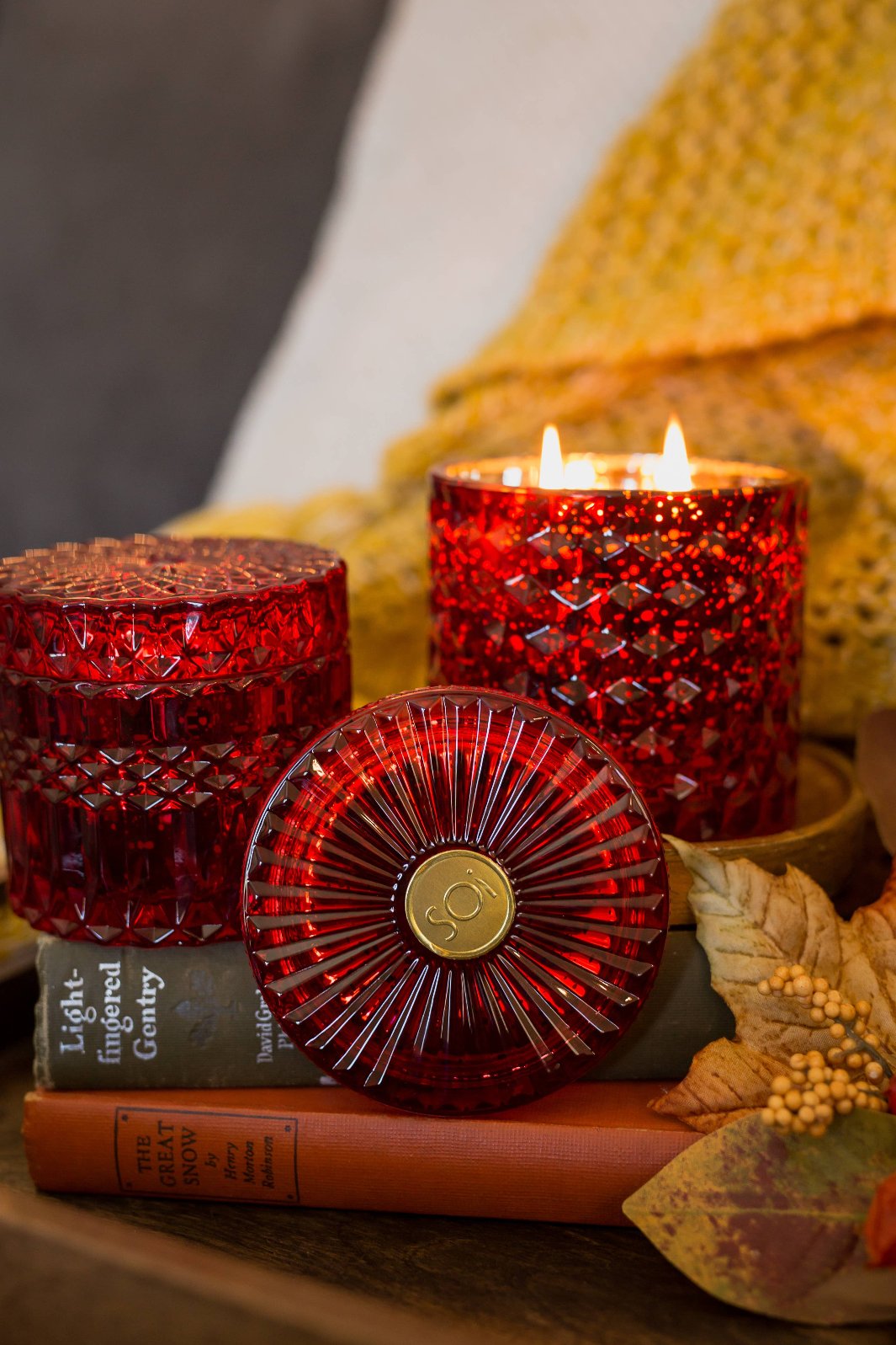 Gorgeous red crystal candle with seasonal aroma of nutmeg, cardamom, and mandarin zest. Shown lit. 