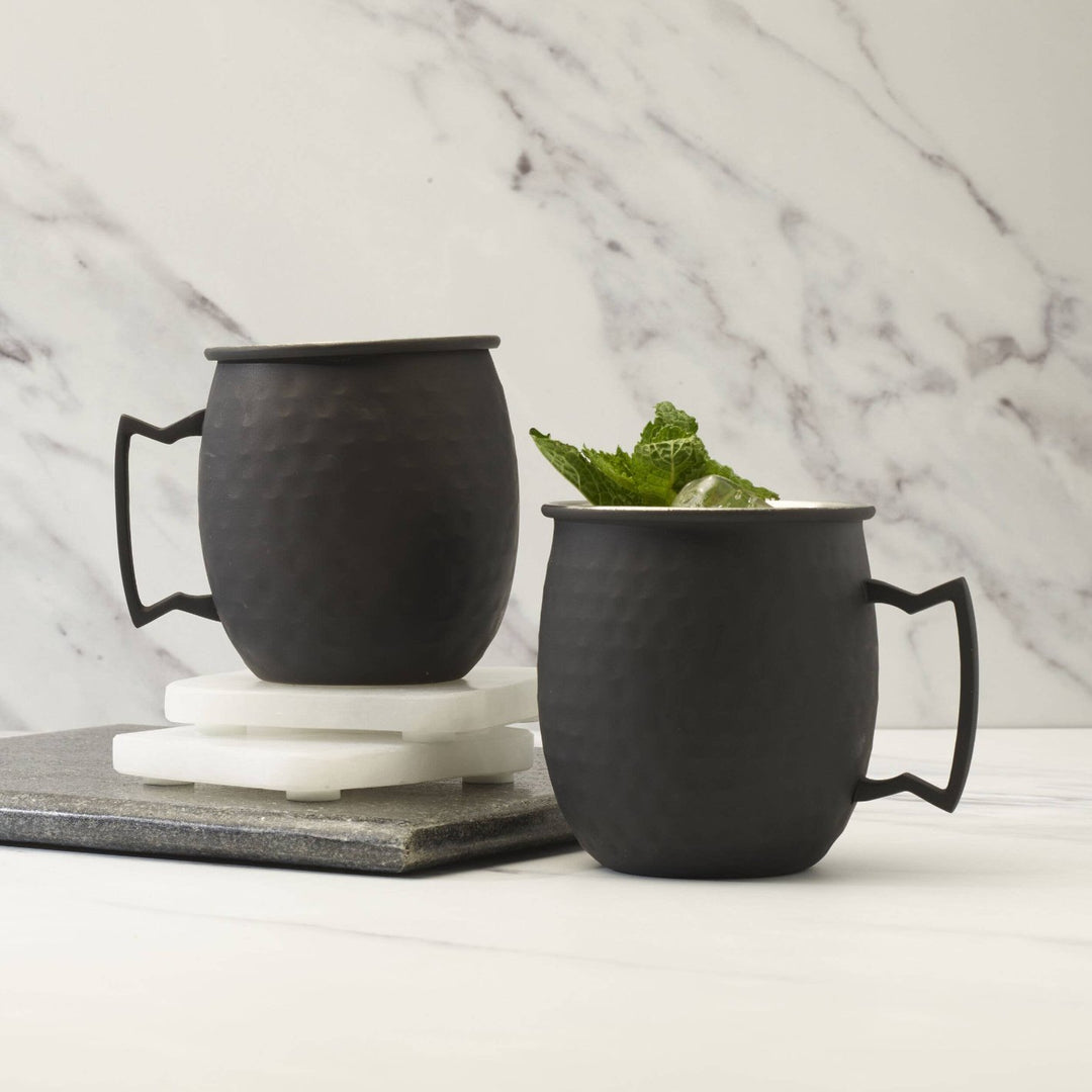 Two black matte hammered Moscow mule mugs by Houdini. 