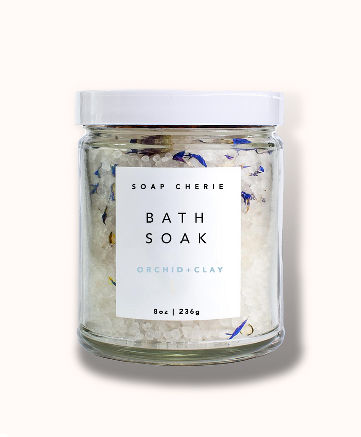 Luxurious bath soak with orchid scent, made with Dead Sea Salt, magnesium, and Cambrian Blue Clay, perfect for a spa-like experience and skin rejuvenation.