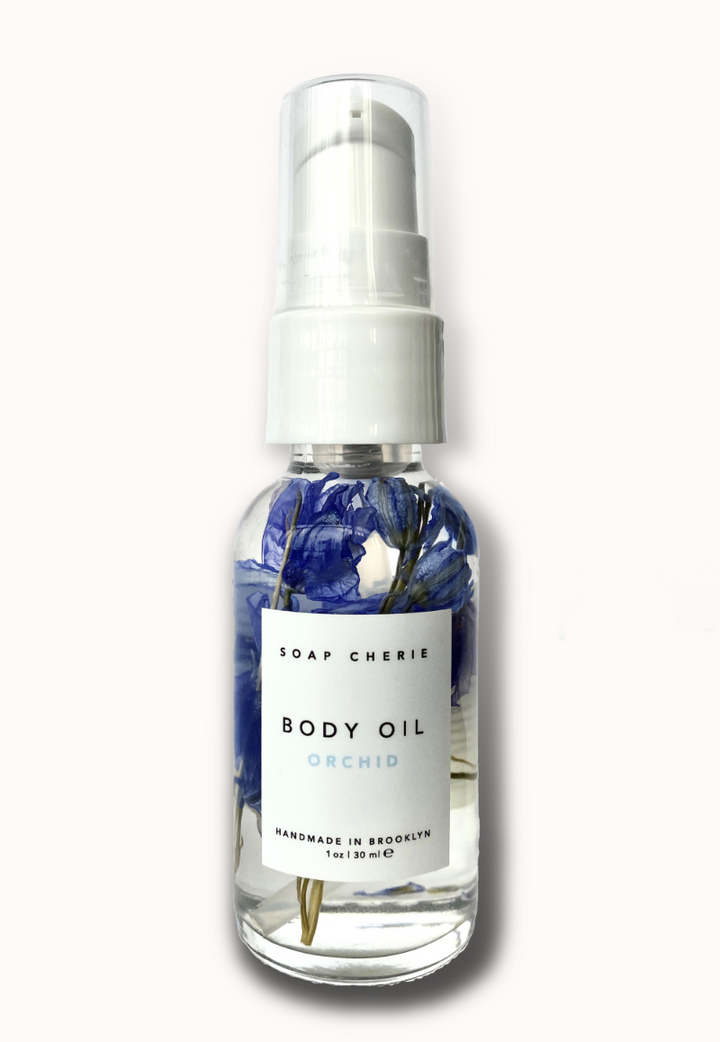 Bottle of Orchid Body Oil, a nourishing blend of cold-pressed botanical oils with soothing lavender and patchouli scent, perfect for daily hydration.