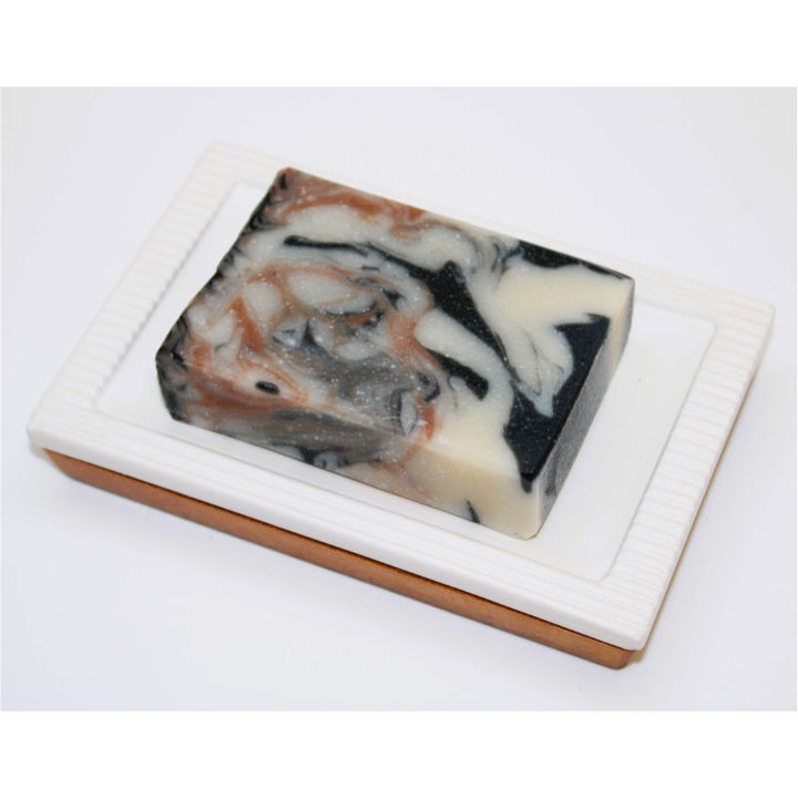 Palo Santo Soap Bar lying flat in a soap dish. 