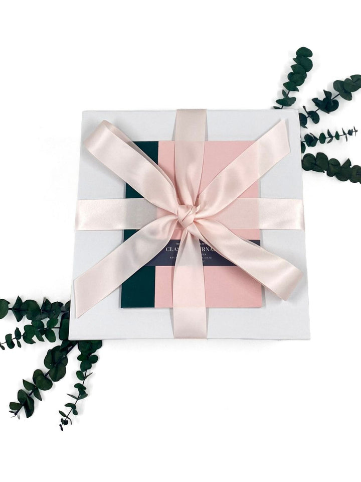 Pretty In Pink Essentials Gift Box adorned with a pink satin ribbon.