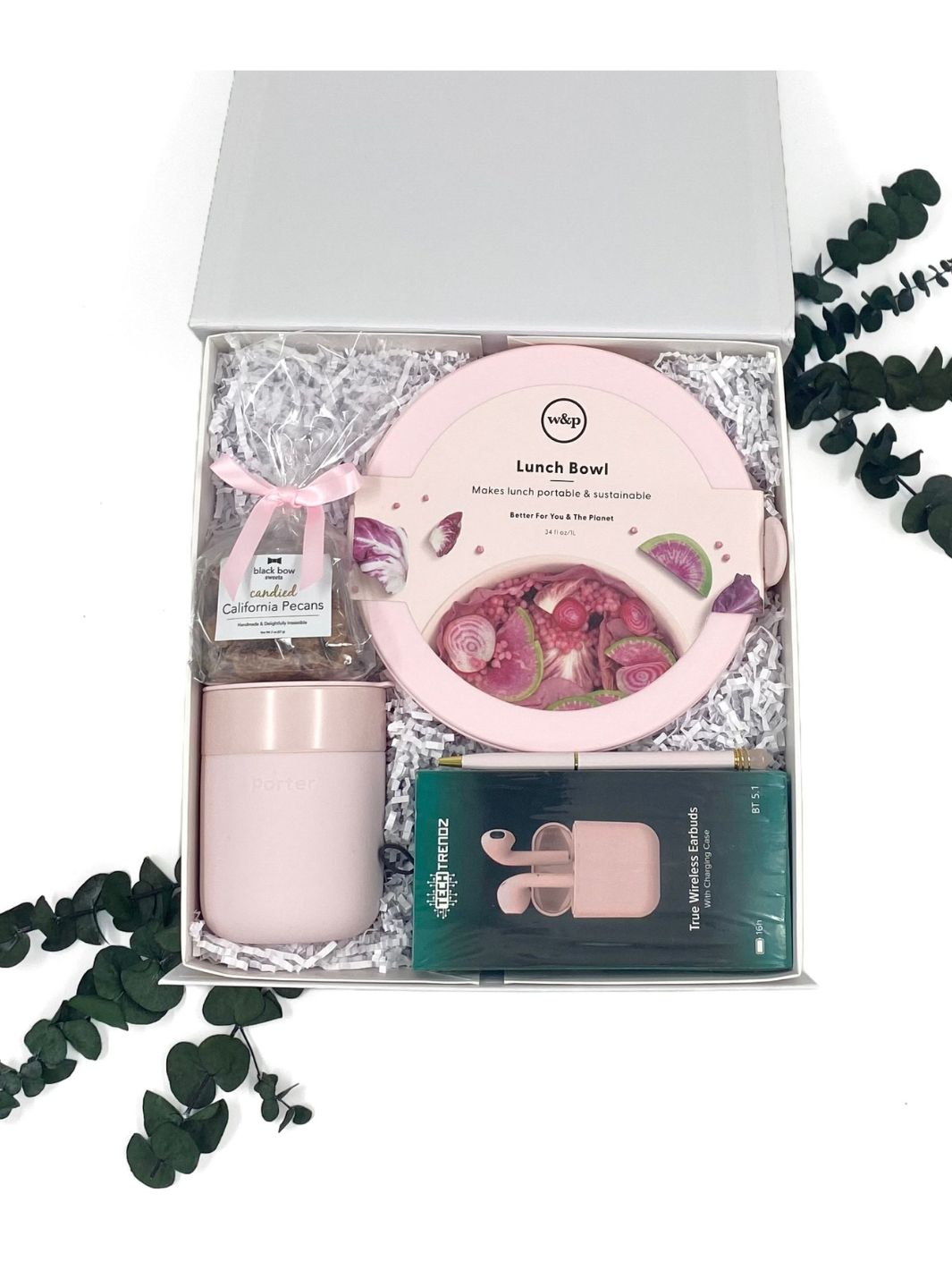 Pretty in Pink Essentials Gift Box showcasing crystal pen, earbuds, ceramic mug, lunch bowl, and candied pecans.