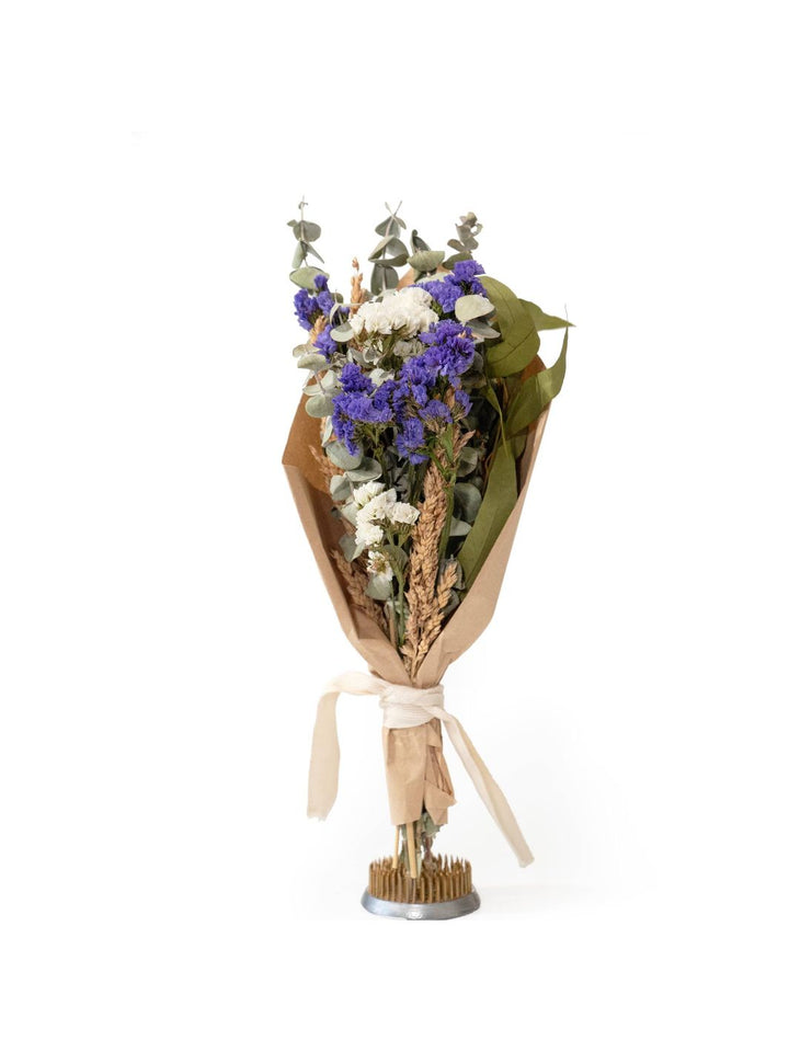 Handcrafted purple floral and eucalyptus bouquet wrapped in Kraft paper with a grosgrain ribbon.