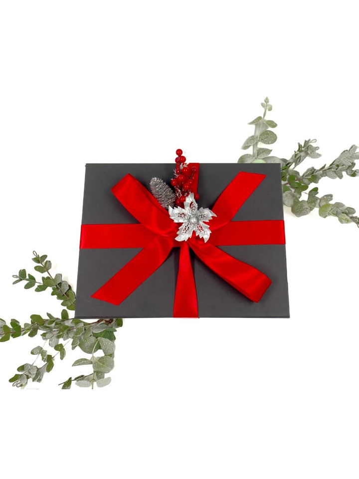 World of Gifting Gift Box with red Christmas ribbon and festive decor on a black gift box. 