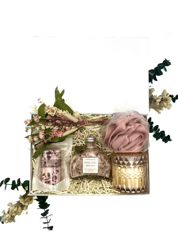 Rose Elegance Spa Gift Set with luxurious bath soak, soy candle, shower steamers, rose loofah, and a charming petit bouquet arrangement.