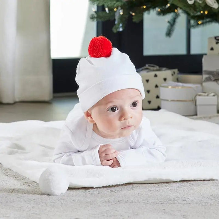 Baby wearing Santa Baby Pom Pom Hat, coordinating with “Santa’s Favorite” Snapshirt.