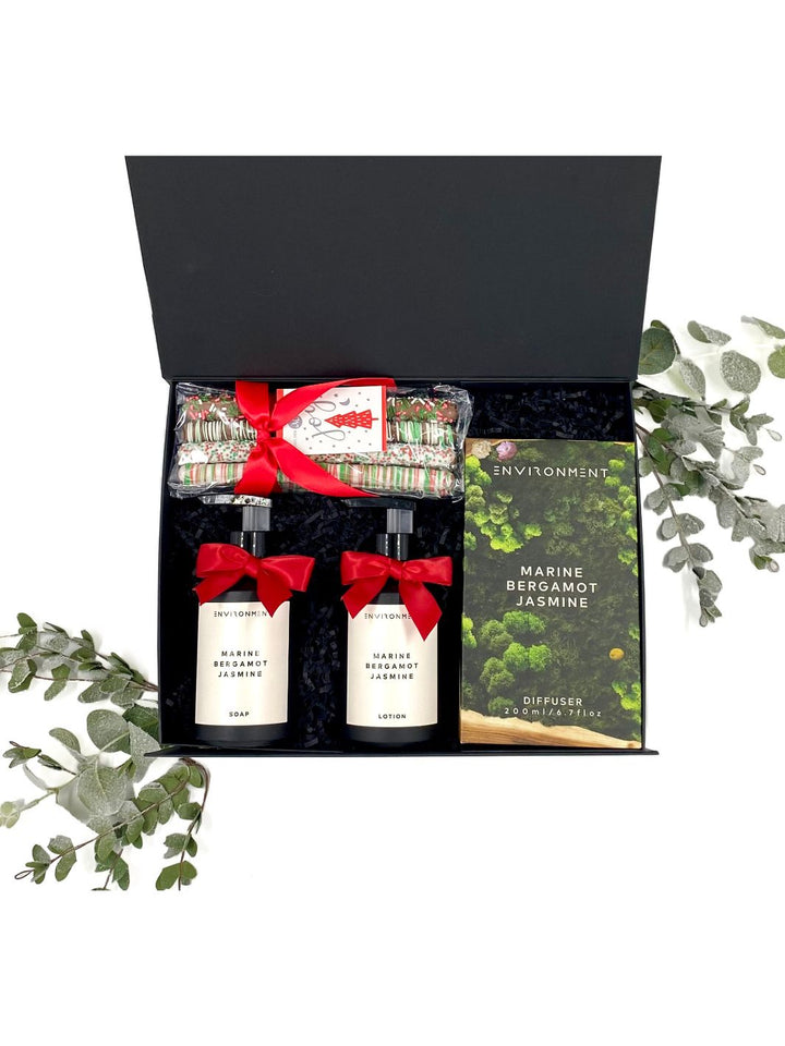 The Ritz Experience Gift Set displayed with a sleek black diffuser, hand soap, hand lotion, and chocolate pretzel rods in elegant packaging.