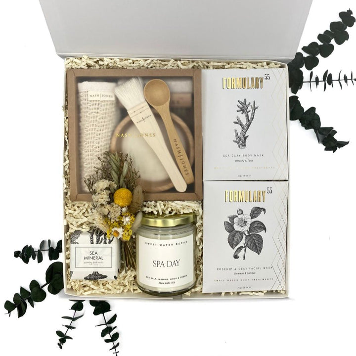 Image of the Ultimate Spa Day Gift Box featuring an 11-piece bath and beauty set including exfoliation tools, masks, candle, and floral bouquet. Ideal for spa gift sets for her, spa gift baskets, and relaxation gifts.