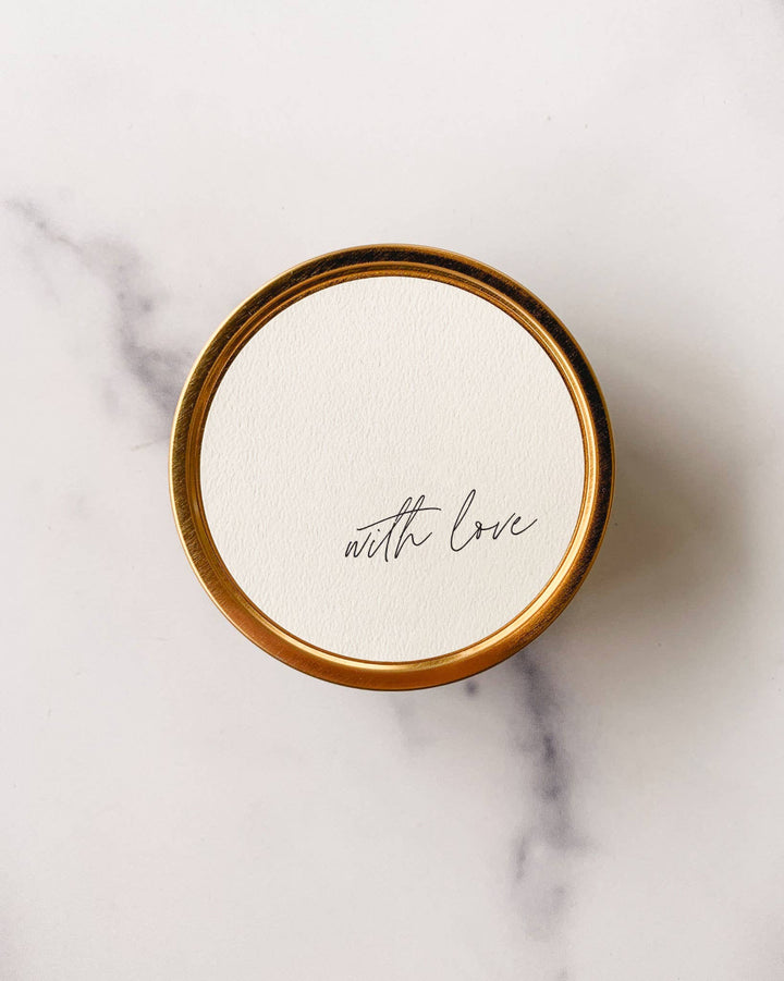 "With Love" Travel Candle in a gold tin with a textured paper label.